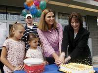 Susan E. Miller, New York Lottery executive deputy director, right, cuts a decorated cake with lottery winner Ginnie Bogaczyk as her fiance, Archie Haner, and their daughters Kyriah, 8, left, and Jordyn, 6, watch Thursday morning in front of the Wilson Farms store on Davis Street in Elmira.