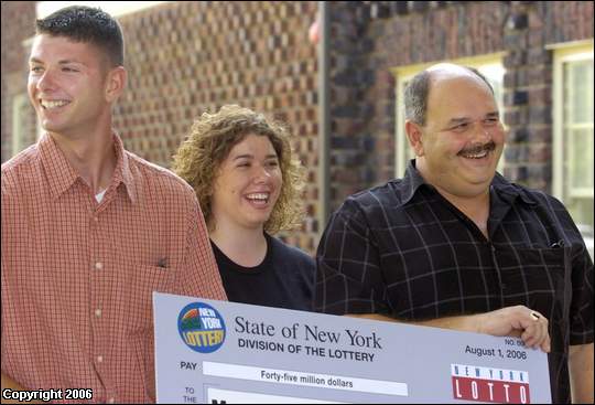 Holding on to the big check, from left, son Josh, daughter Julie and husband John watch as Mary Ann Hrywnak of Johnson City tells her story of buying the winning lottery ticket during the announcement Tuesday at Traditions at the Glen.