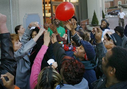They couldn't wait: Hoosier Lottery Executive Director Esther Schneider (left) struggled to release a balloon Wednesday in Downtown Indianapolis as people reached to take it from her. Some of the 200 balloons carried a ticket redeemable for a $25 Holiday Raffle lottery ticket.