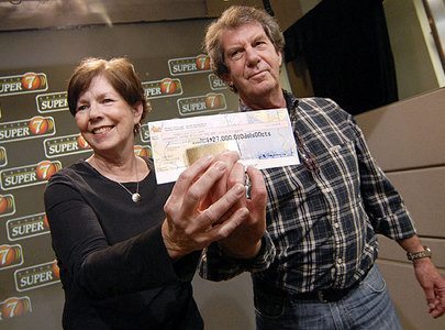 Doug and Liz Kinsman show off their Lotto Super 7 jackpot check for $27 million May 26.