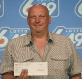 Barry Shell poses with his cheque for nearly $4.4 million at the OLG office on Monday, shortly before his arrest.